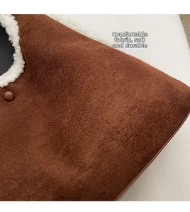 Detail of brown faux suede tote bag featuring plush white fleece trim and a matte snap button