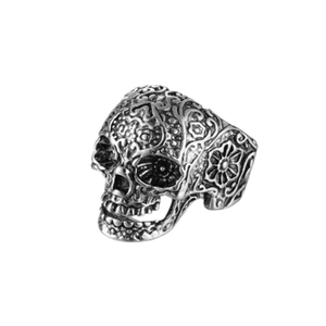 Detailed macro view of vintage silver skull ring with intricate floral carvings on metal