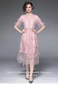 Détail de la robe en tulle rose avec broderie dorée, volants étagés et col de perles