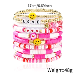Detail of pink bohemian layered stretch bracelets with LOVE beads and charms