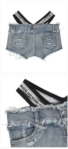 Dettaglio macro di pantaloncini di denim azzurro con bordi sfrangiati e fasce logo incrociate