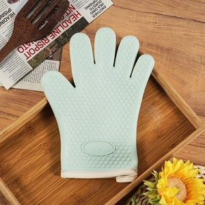 Thickened green silicone oven mitt with heart pattern on a wooden tray for kitchen