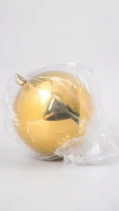 Détail d'une grande boule de Noël dorée brillante dans son emballage de protection