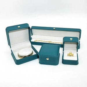 Detail view of teal leather jewelry gift boxes with gold crown and velvet lining