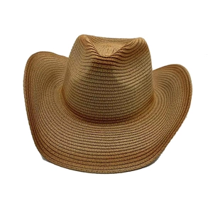 Detail of a brown woven wide brim straw cowboy hat with a curved brim and a high crown