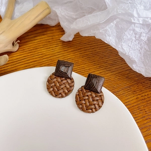 Handmade woven circular straw stud earrings with dark brown wood accents in retro style