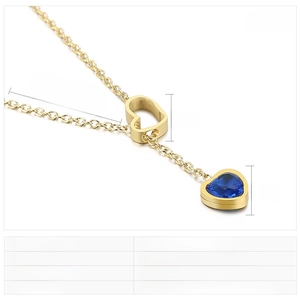 Macro detail of gold stainless steel necklace with blue heart crystal pendant charm