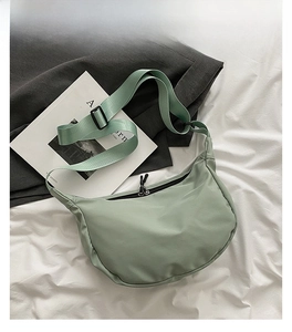Detail of mint green waterproof nylon crescent crossbody bag with double zipper closure