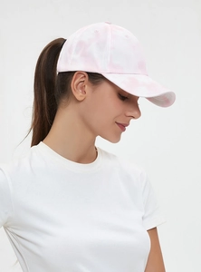 Side view of woman wearing a pink and white tie-dye baseball cap in premium cotton canvas