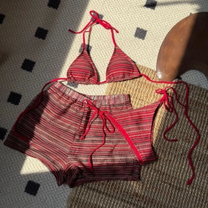 Detaillierte Textur des rot gestreiften Strickstoffs von Bikini-Oberteil und Shorts