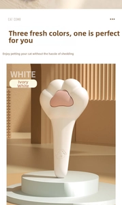 Gros plan d'une brosse chat patte ivoire avec poignée ergonomique et picots de massage