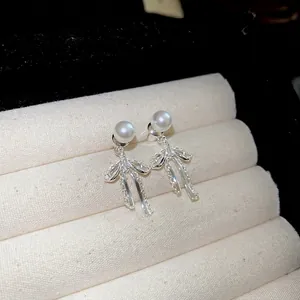 Elegant 925 silver pearl earrings with lace bow pendant displayed in a jewelry box
