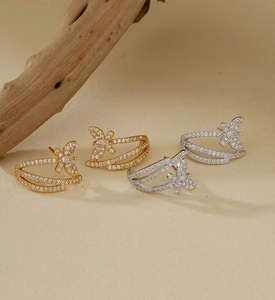 Detailed view of silver and gold butterfly stud earrings with shimmering zircon stones