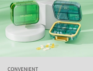 Macro detail of portable 4-compartment medicine organizer with gold buckle on white stand