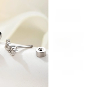 Macro view of silver stud earring with threaded screw back and polished finish