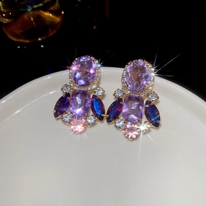 Macro shot of vintage gold earrings with colorful crystals and sparkling starburst effects