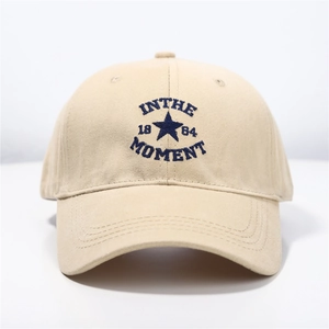 Beige cotton embroidered baseball cap featuring In The Moment text and navy blue star