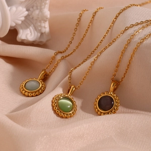 Three gold sun necklaces with blue, green, and purple stones on satin fabric