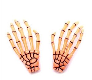 Macro shot of orange and black gothic skeleton claw hair clips on a white background