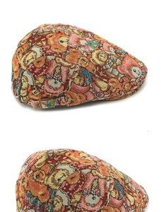 Detailed close-up of retro jacquard beret featuring bear and lion patterns and metal buckle