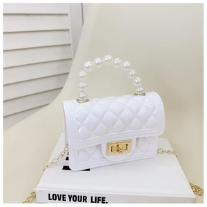 Detail of white mini jelly bag featuring quilted texture and elegant pearl handle