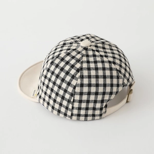 Detail of baby gingham baseball cap with a metal buckle and beige adjustable strap