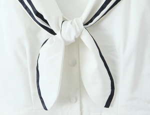 Detail of nautical collar with navy stripes and fabric buttons on white linen dress