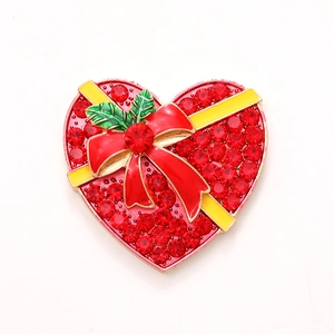 Sparkling red heart brooch with crystals and gold edges on white background
