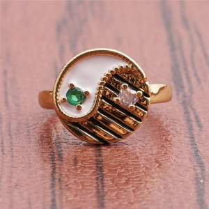 Macro shot of gold yin-yang open ring with zircon inlay and enamel details