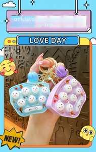 Detail view of mini handheld Whac-A-Mole keychain games in blue and purple colors