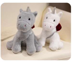 Detailed close-up of plush unicorn toys with shiny silver horns and rose decorations
