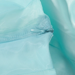 Gros plan d'une fermeture éclair invisible sur tissu bleu clair pour ensemble d'été