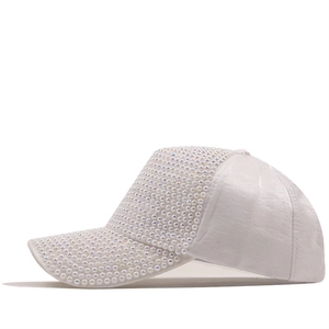 Dettaglio del cappellino da baseball in cotone bianco con perle e strass colorati