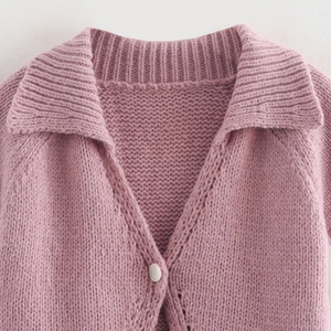 Pink knit cardigan with V-neck collar and single-button closure in soft texture