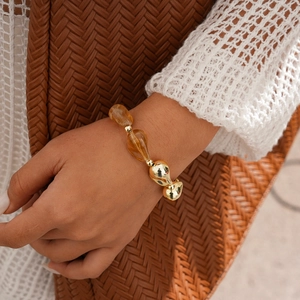 Détail d'un bracelet ethnique avec perles géométriques en acrylique ambre et métal doré