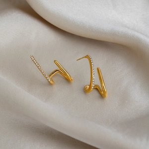 Close-up of 18K gold plated irregular linear earrings with micro-pave crystal zircons