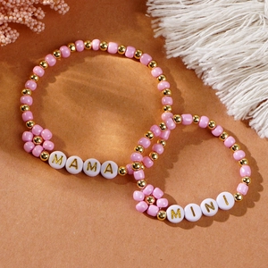 Macro view of MAMA and MINI pink beaded bracelets with gold accents for mother and child