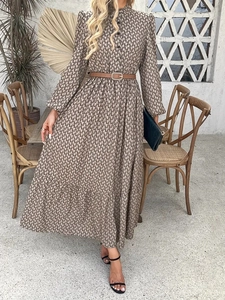 Detail of bohemian long-sleeved dress featuring vintage geometric patterns and a brown belt