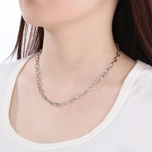 Minimalist silver elongated link chain necklace shown on a model against a white background