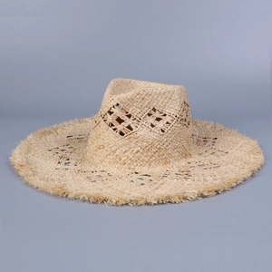 Detail of raffia sun hat featuring diamond hollow weave and natural frayed brim edges