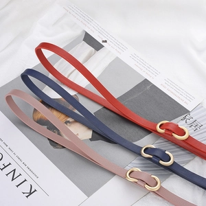 Three minimalist slim leather belts in red, navy, and pink with golden D-rings for women