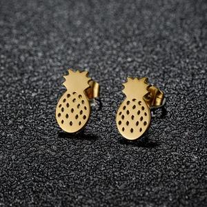 Golden pineapple stud earrings with hollow texture and leaf detail on dark grey background