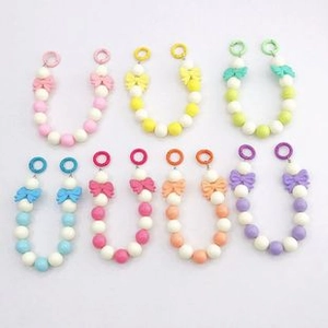 Detailed view of colorful beaded phone straps featuring elegant bow accents and clips