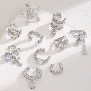 Detailed view of silver ear cuffs and earrings set with zircon stars and crosses