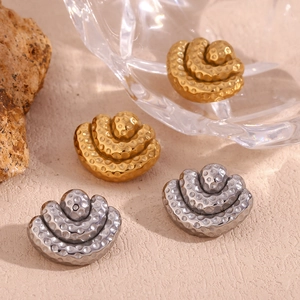 Detailed view of 18K gold and silver tiered fan earrings with hammered texture on stone