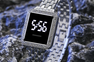 Close-up of square LED digital watch with rhinestone bezel and silver metal band