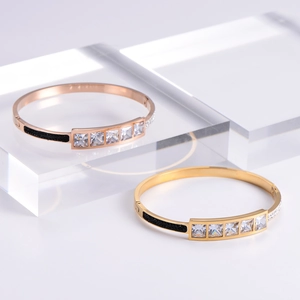 Luxurious gold and rose gold bangles with square zircon stones on acrylic stands