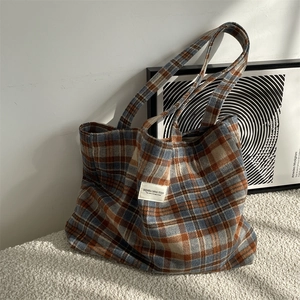 Detail of vintage plaid woolen tote bag texture with minimalist woven brand patch