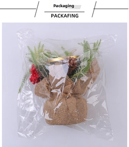 Detail of Christmas candle holder with red berries and pine cones in burlap base packaging