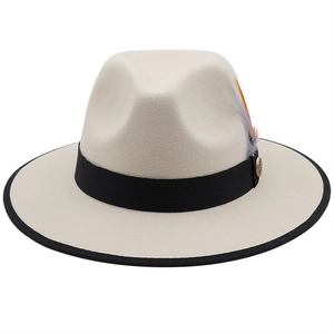 Detail of cream wool fedora featuring colored feather, gold emblem and black ribbon trim